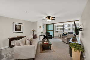 Carpeted living room with ceiling fan