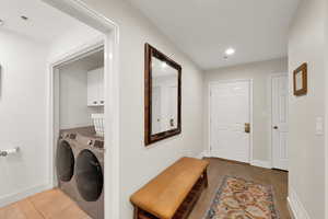 Laundry area featuring light hardwood / wood-style floors, cabinets, and independent washer and dryer