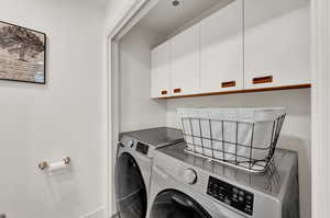 Laundry area featuring cabinets and washing machine and clothes dryer