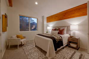 Bedroom featuring light colored carpet and vaulted ceiling