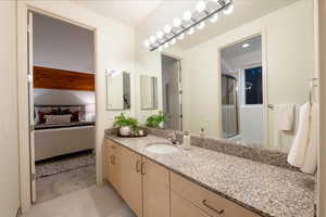 Bathroom featuring vanity, a shower with shower door, and tile patterned flooring