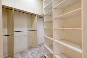 Walk in closet featuring light colored carpet