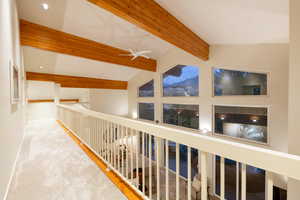 Hall with lofted ceiling with beams and carpet