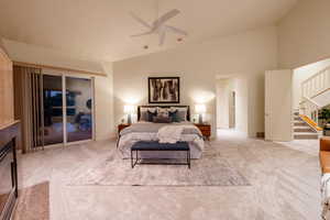 Bedroom featuring ceiling fan, high vaulted ceiling, access to outside, and light colored carpet