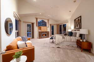 Bedroom with a high end fireplace, high vaulted ceiling, carpet flooring, and access to outside