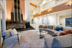 Carpeted living room with beamed ceiling and high vaulted ceiling