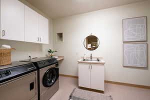 Laundry room featuring cabinets, sink, and separate washer and dryer