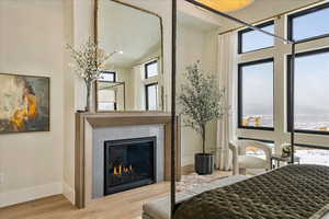 Bedroom with hardwood / wood-style floors and high vaulted ceiling