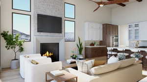 Living room featuring beam ceiling, ceiling fan, light hardwood / wood-style flooring, a fireplace, and a towering ceiling