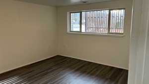 Unfurnished room featuring dark wood-type flooring