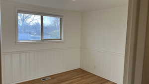 Empty room with wood-type flooring and ornamental molding