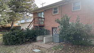 Rear view of property with cooling unit