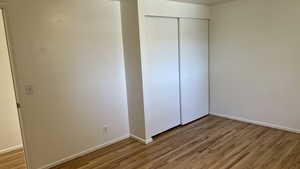 Unfurnished bedroom featuring a closet and light hardwood / wood-style flooring