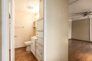 Bathroom with hardwood / wood-style flooring, toilet, ceiling fan, and vanity