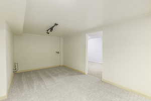 Carpeted spare room with rail lighting