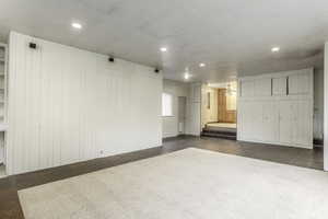 Carpeted empty room featuring wood walls