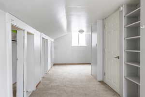 Hall featuring light colored carpet and lofted ceiling