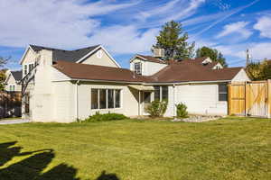 View of front of home with cooling unit and a front yard