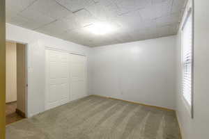 Unfurnished bedroom with carpet and a closet