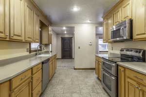 Kitchen featuring sink, a textured ceiling, and stainless steel appliances