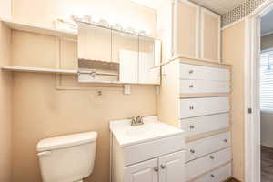 Bathroom featuring hardwood / wood-style flooring, toilet, and vanity