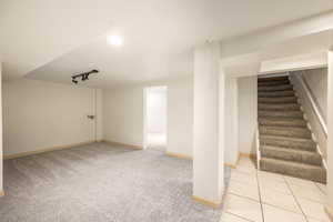 Interior space featuring light colored carpet and track lighting