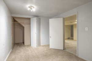 Unfurnished bedroom with a closet and light carpet