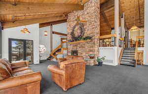 Carpeted living room featuring high vaulted ceiling, beamed ceiling, and wooden ceiling