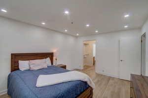 Bedroom with ensuite bathroom and light hardwood / wood-style flooring