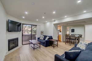 Living room featuring light wood-type flooring and a tiled fireplace