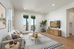 Living room featuring french doors, a textured ceiling, and light hardwood / wood-style flooring