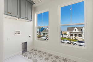 Laundry area featuring hookup for a washing machine, electric dryer hookup, and upper cabinets