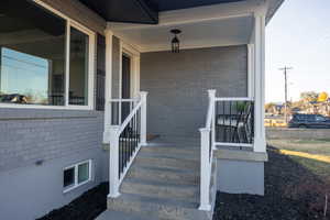 Entrance to property featuring covered porch