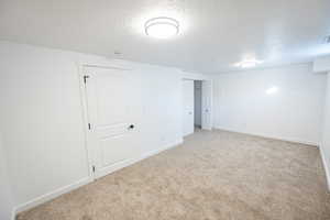 Carpeted empty room with a textured ceiling