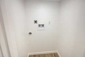 Washroom featuring hookup for an electric dryer, hardwood / wood-style floors, and washer hookup