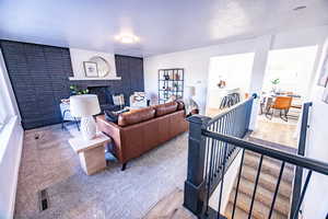 Living room featuring wood-type flooring and a brick fireplace