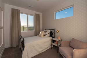 Bedroom with dark colored carpet and a mountain view