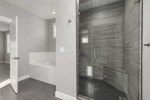 Primary bathroom with shower, separate bathtub, and tile patterned flooring