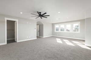 Bonus room featuring light carpet, ceiling fan, and bathroom