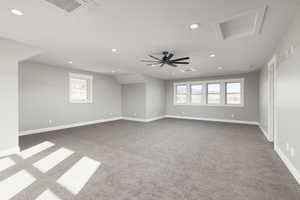 Carpeted Bonus room featuring plenty of natural light and ceiling fan