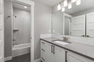 Bathroom with vanity, tile patterned flooring, and shower / bathtub combination