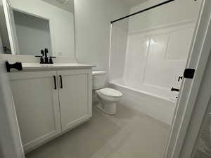 Full bathroom with tile patterned flooring, vanity, toilet, and shower / washtub combination