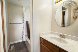 Bathroom featuring vanity and shower / bath combination with curtain