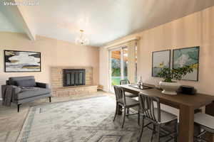 Virtually Staged - Dining area featuring beam ceiling, a notable chandelier, a stone fireplace, and carpet floors