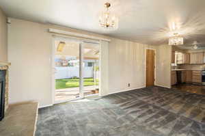 Dining area featuring an inviting chandelier, sink, and dark colored carpet