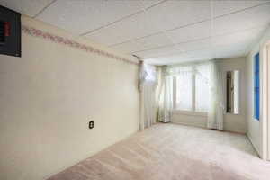 Carpeted spare bedroom featuring a paneled ceiling