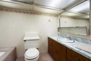 Bathroom with vanity, toilet, and a tub