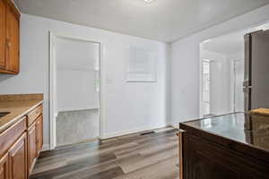 Kitchen featuring hardwood / wood-style flooring, a barn door, range, a textured ceiling, and stainless steel refrigerator