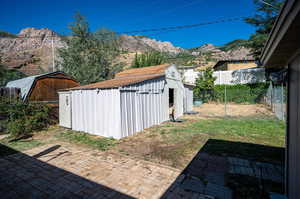 View of yard featuring a mountain view, a shed, and a patio area