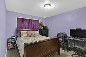 Carpeted bedroom with a textured ceiling